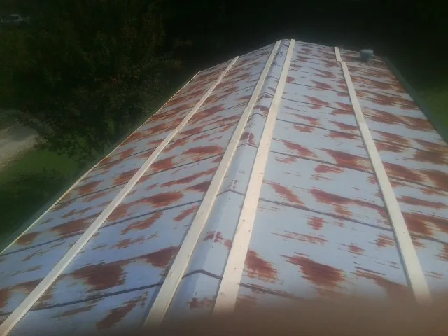 Rusted metal roof panels with new wood purlins before replacement — Storm Damage Roof Repair in Onondaga by Roofing Brothers