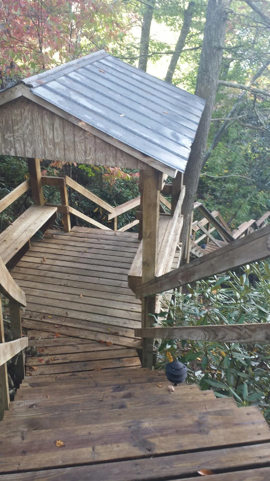 Metal roofed shelter over wooden steps on a wooded walkway — Skylight Repair & Installation work by our crew in Onondaga