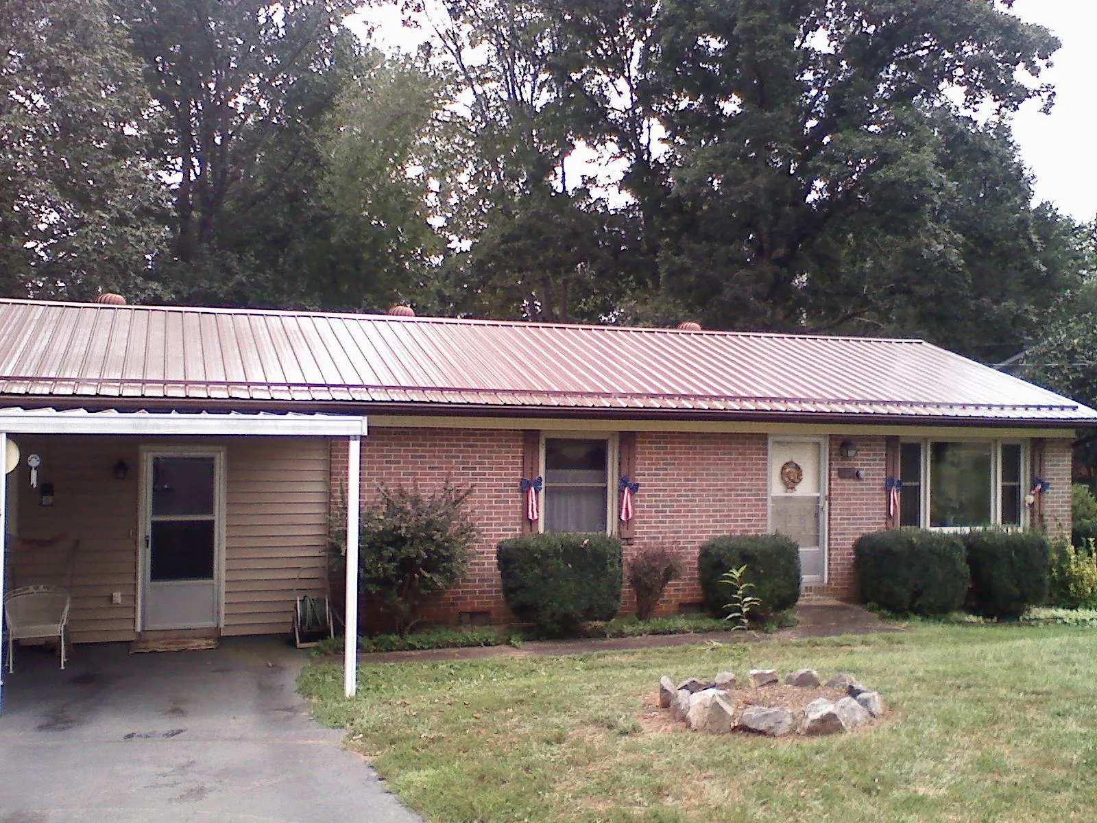 Bronze metal roof and carport on a brick ranch home — Roof Repair work by our crew in Onondaga